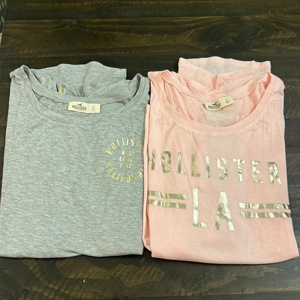 Two Hollister T-shirts. Gray with gold foil detail. Pink with gold foil detail.